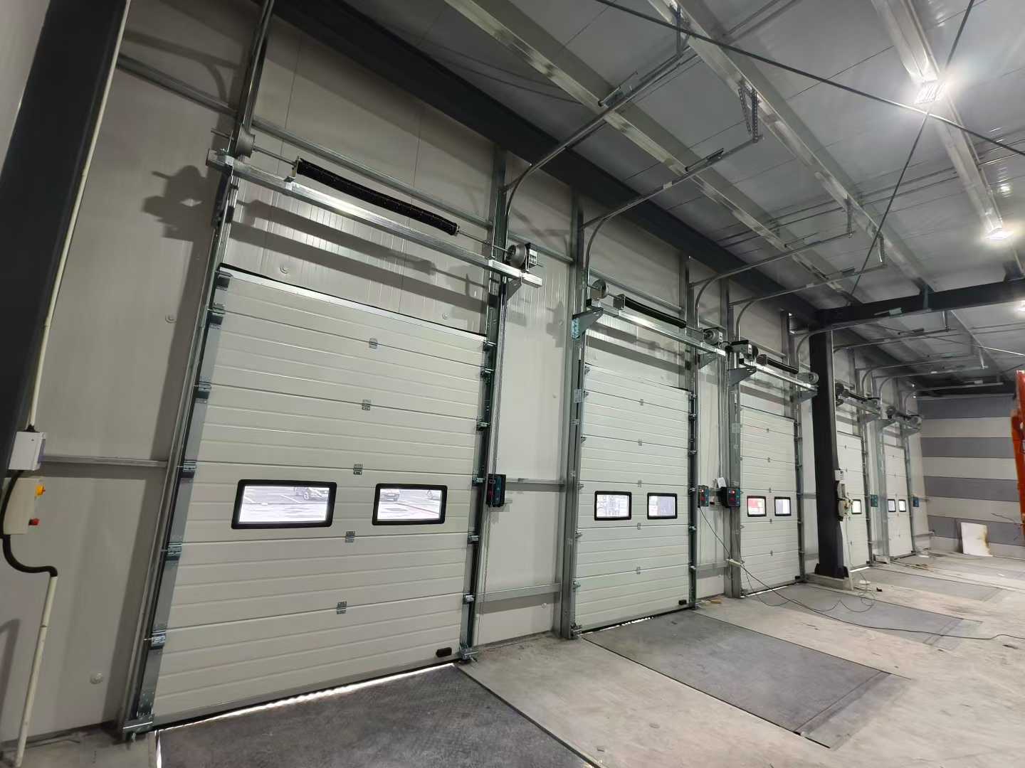 گودام کے منصوبوں کے لیے صنعتی سیکشنل دروازے اور گودی لیولرز کی کھیپ